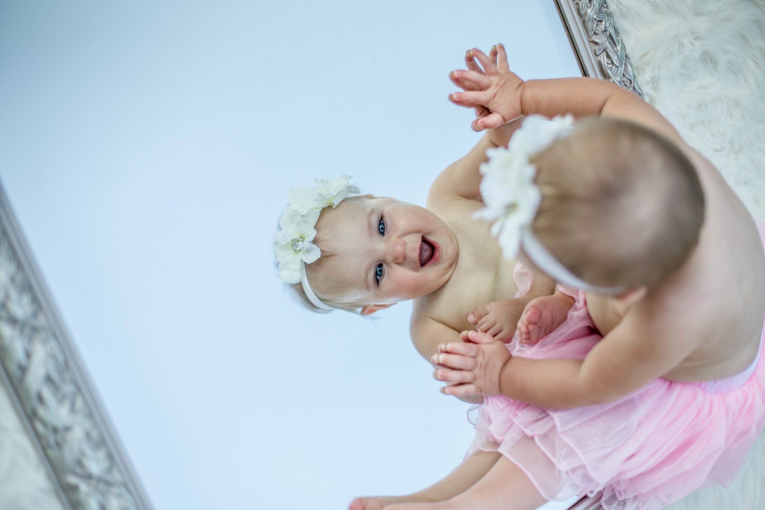 Toddler looking in the mirror with an expression of joy
